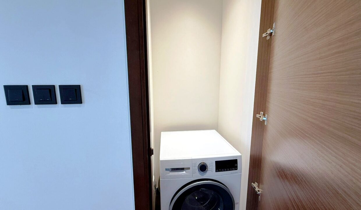 Waschraum des Apartments in Sobha Hartland mit Waschmaschine und Trockner